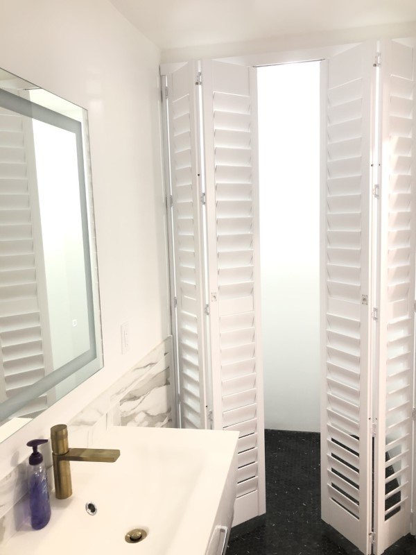 Norman clear view bi-fold shutters for a new modern bathroom.